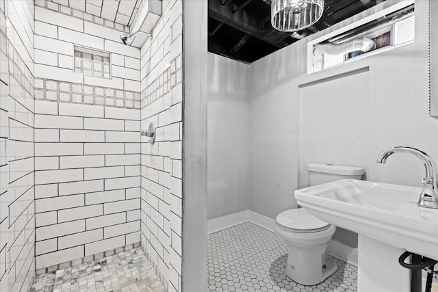 18603 Monica St, Detroit, MI 48221 - bathroom featuring toilet, a tile shower, tile patterned flooring, and a sink