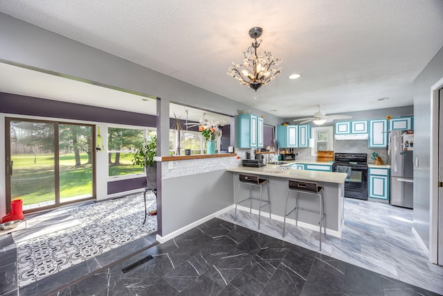7364 Regency Ln, Canadian Lakes, MI 49346 - kitchen with electric range, light countertops, a kitchen breakfast bar, freestanding refrigerator, and a peninsula