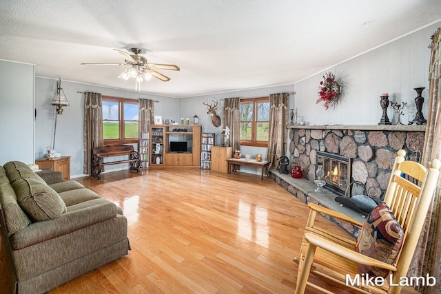 4297 Lutheran Church Rd NW, Kent City, MI 49330 - living room featuring a fireplace, a ceiling fan, wood finished floors, and a healthy amount of sunlight