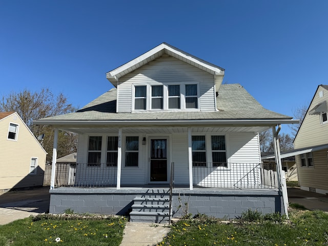bungalow-style home featuring covered porch and a shingled roof