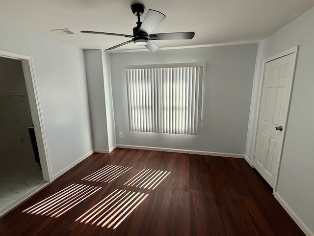 unfurnished bedroom with wood finished floors, ceiling fan, visible vents, and baseboards