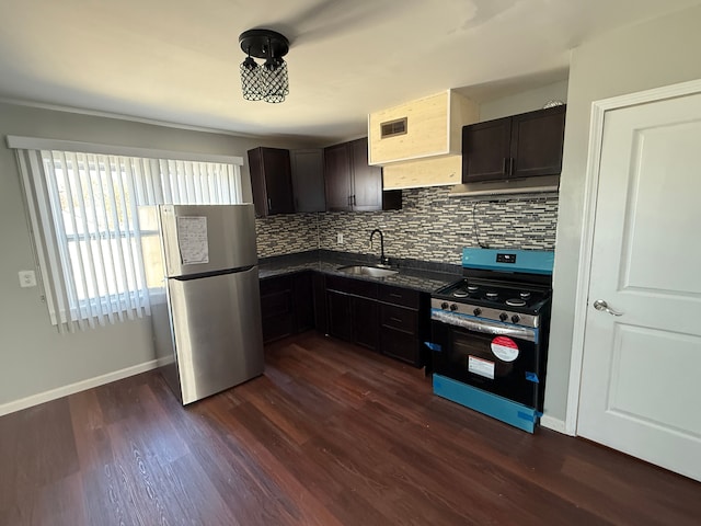 kitchen featuring dark wood-style flooring, stainless steel appliances, decorative backsplash, and a sink