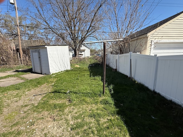 view of yard with fence, an outdoor structure, and a shed