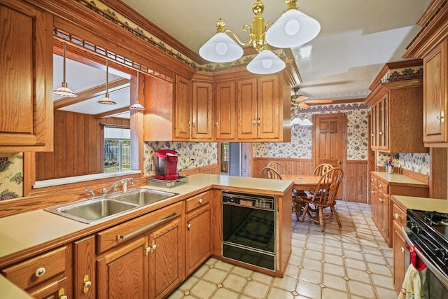 kitchen with a sink, dishwasher, a chandelier, a wainscoted wall, and wallpapered walls