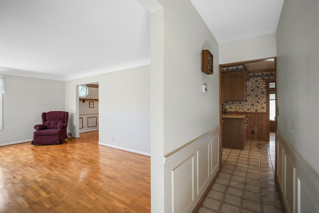 hall featuring wainscoting and a healthy amount of sunlight