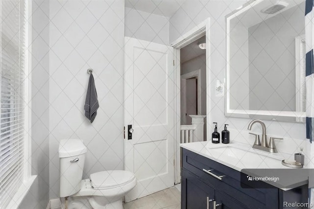 bathroom with toilet, vanity, tile walls, and tile patterned flooring