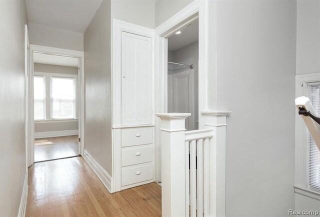 hall featuring baseboards and light wood-style floors