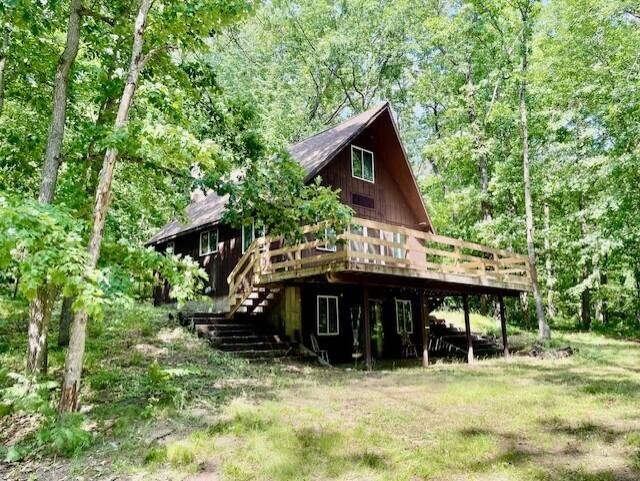 238 Maple St, Bitely, MI 49309 - back of house featuring a wooden deck, stairway, and a forest view