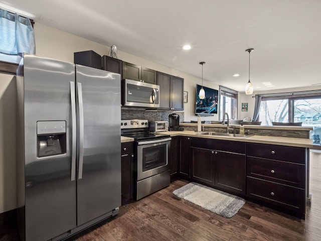 3190 Edgewood Park Dr, Commerce Twp, MI 48382 - kitchen featuring a peninsula, dark wood-type flooring, light countertops, a sink, and stainless steel appliances