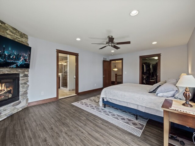 3190 Edgewood Park Dr, Commerce Twp, MI 48382 - bedroom with wood finished floors, a fireplace, baseboards, a walk in closet, and recessed lighting