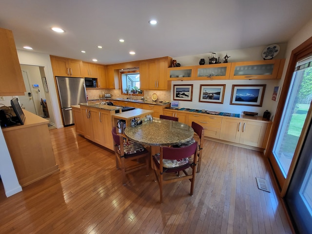 6358 Timberwood S, West Bloomfield, MI 48322 - kitchen with freestanding refrigerator, black microwave, a kitchen island, and light wood finished floors
