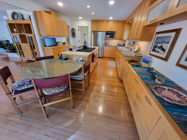 6358 Timberwood S, West Bloomfield, MI 48322 - kitchen with a kitchen island, black microwave, light wood-type flooring, stainless steel fridge, and a sink