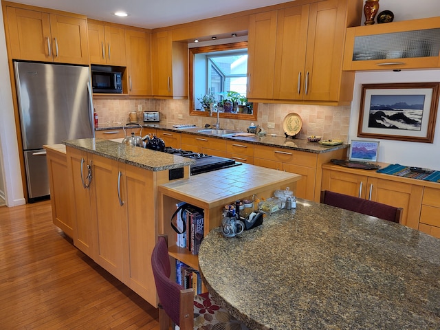 6358 Timberwood S, West Bloomfield, MI 48322 - kitchen with black microwave, a sink, freestanding refrigerator, decorative backsplash, and light wood-type flooring