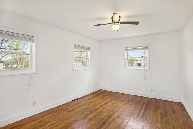 spare room with hardwood / wood-style floors, baseboards, a ceiling fan, and plenty of natural light