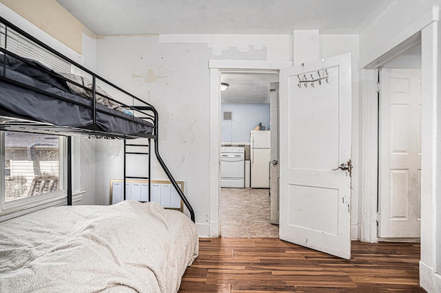 bedroom with wood finished floors and freestanding refrigerator