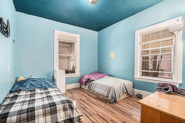 bedroom featuring wood finished floors and baseboards