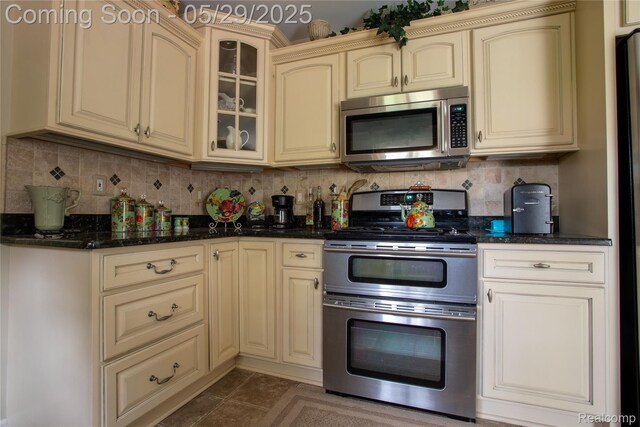 140 Indian Knolls St, Oxford, MI 48371 - kitchen featuring cream cabinetry, appliances with stainless steel finishes, tile patterned flooring, and backsplash