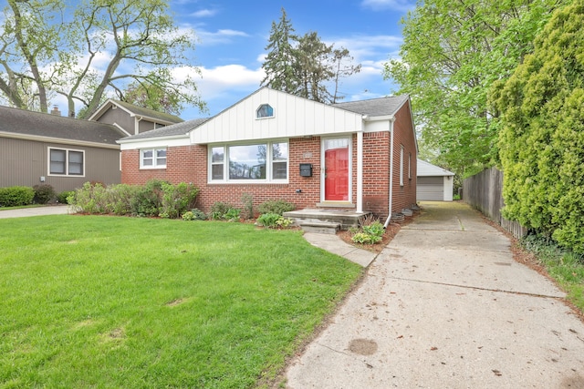 bungalow-style home with fence, an outbuilding, a front lawn, and brick siding