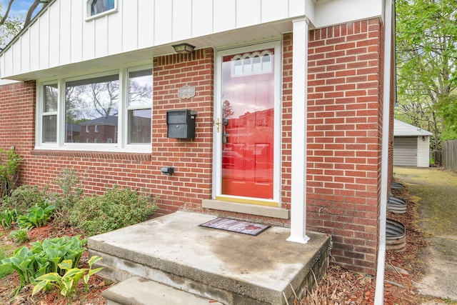 property entrance featuring brick siding and board and batten siding