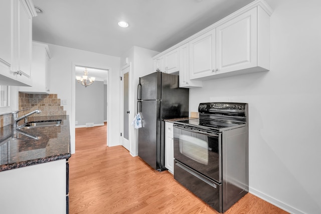 kitchen featuring decorative backsplash, white cabinetry, a chandelier, a sink, and black appliances