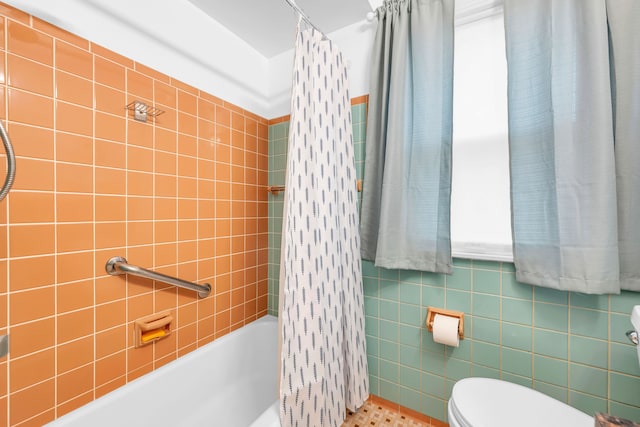 full bathroom with shower / tub combo with curtain, toilet, and tile walls