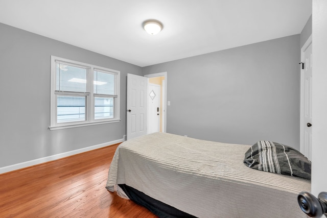 bedroom with baseboards and wood finished floors