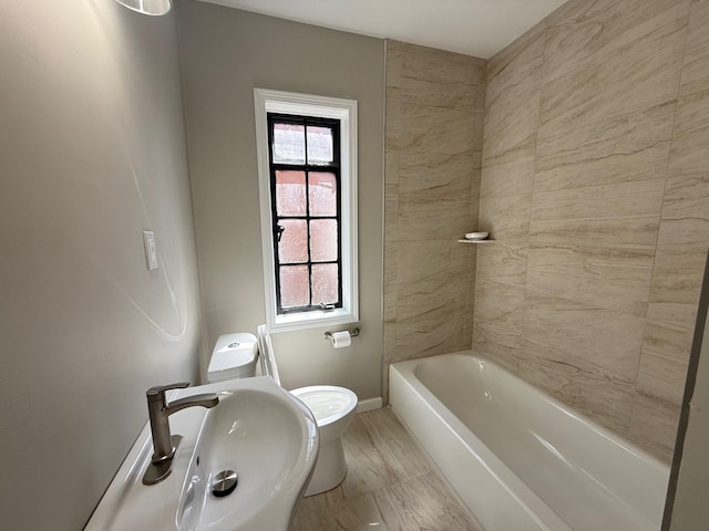 full bathroom featuring a sink, toilet, plenty of natural light, and baseboards
