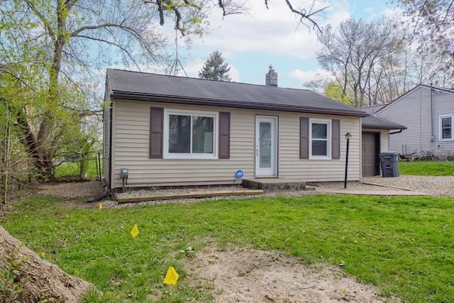 view of front of home with fence, a chimney, a front yard, and a garage