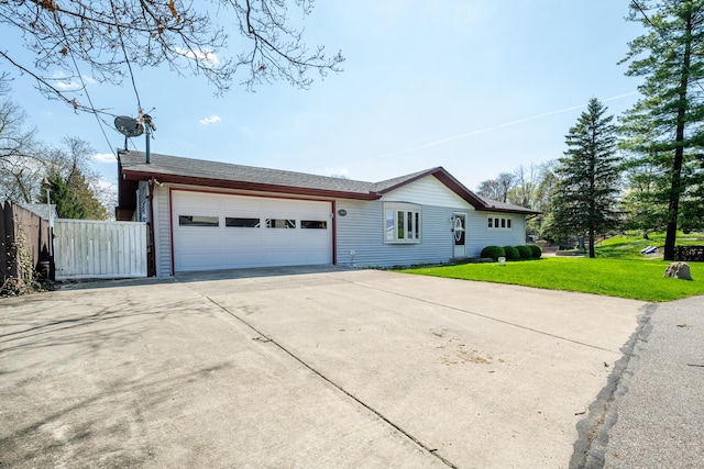 exterior space with a garage, fence, a front yard, and concrete driveway