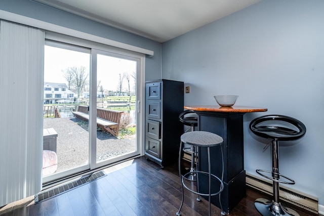 dining area with baseboard heating and dark wood finished floors