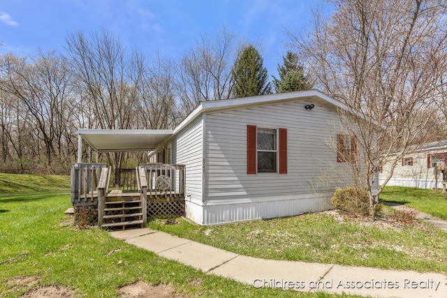 view of side of property featuring a wooden deck and a yard
