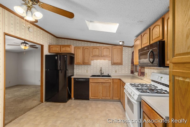 kitchen featuring black appliances, ceiling fan, wallpapered walls, and a sink
