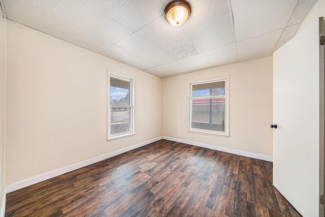 empty room with dark wood finished floors and baseboards