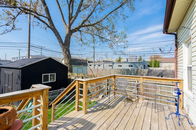 wooden deck featuring fence, an outdoor structure, and a storage shed