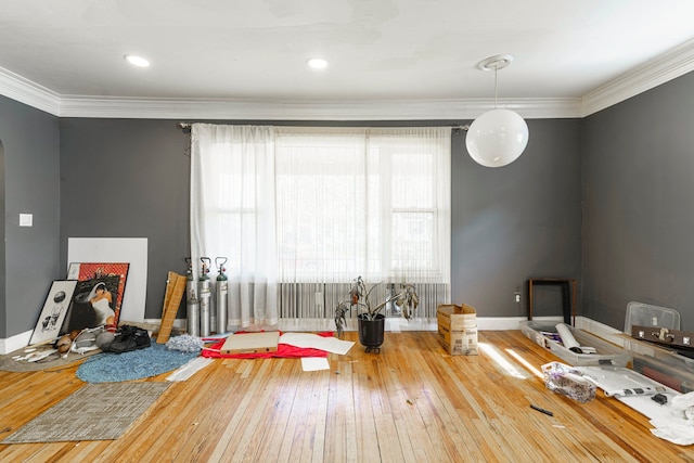 playroom featuring hardwood / wood-style floors, arched walkways, crown molding, and baseboards