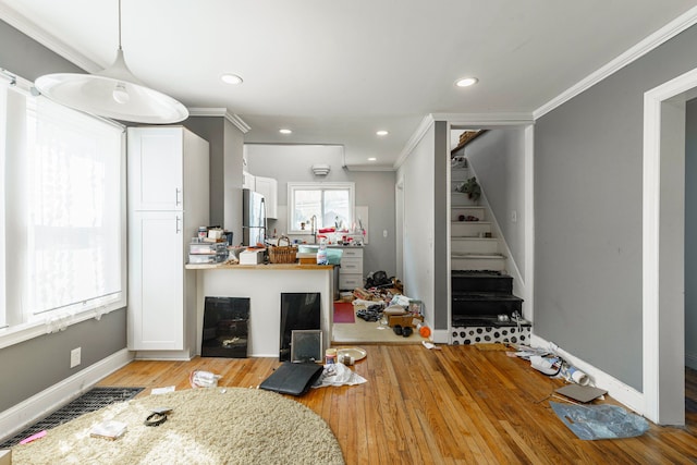 living room with light wood-type flooring, ornamental molding, stairs, and recessed lighting
