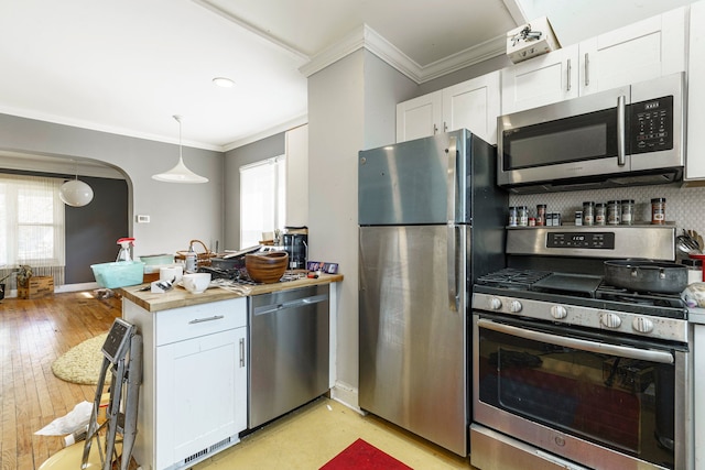 kitchen featuring crown molding, white cabinets, and stainless steel appliances