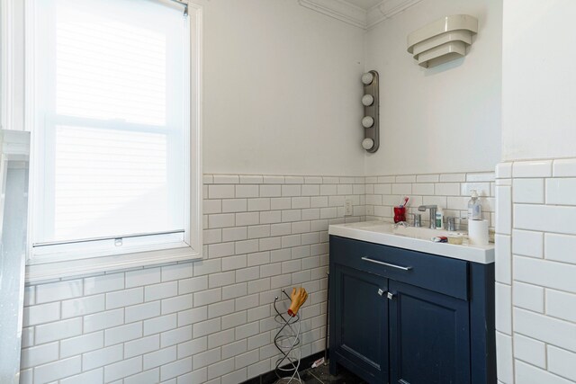 bathroom with vanity, ornamental molding, wainscoting, and tile walls