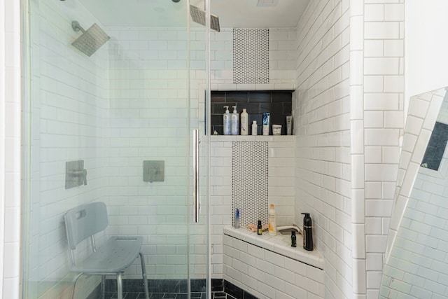 full bath featuring tile walls and a shower stall