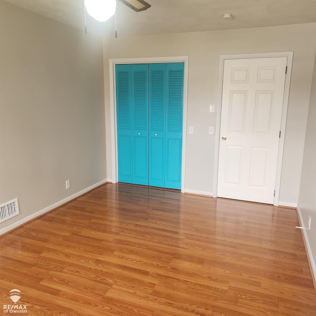unfurnished bedroom featuring a ceiling fan, baseboards, visible vents, and light wood finished floors