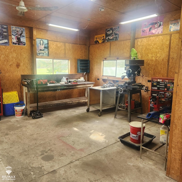 miscellaneous room featuring a wealth of natural light, a workshop area, and unfinished concrete flooring