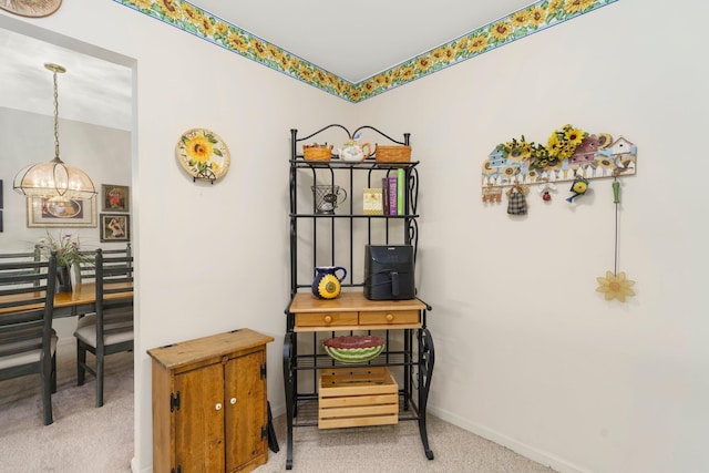 interior space with baseboards, an inviting chandelier, and carpet
