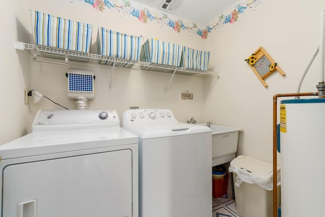 laundry area featuring a sink, water heater, laundry area, and washing machine and dryer