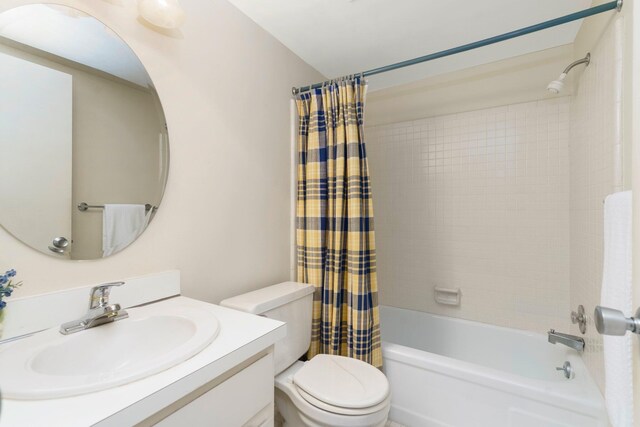 full bathroom featuring shower / bath combo, vanity, and toilet