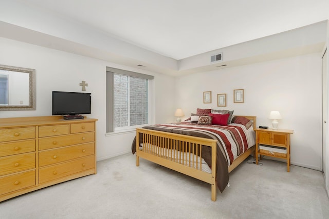 bedroom featuring visible vents, light colored carpet, and baseboards