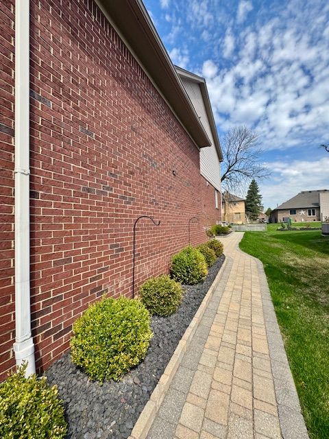 view of side of property featuring a yard and brick siding