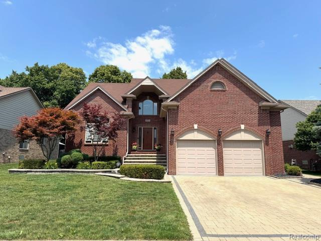 8535 Lillian Dr, Washington, MI 48094 - traditional-style home with brick siding, decorative driveway, and a front yard