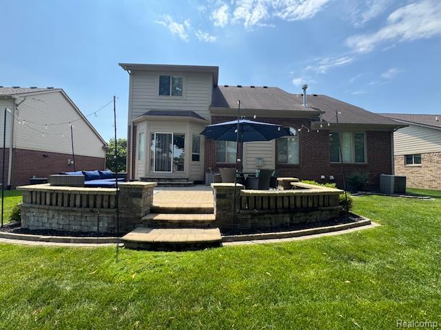8535 Lillian Dr, Washington, MI 48094 - back of property featuring a yard, outdoor lounge area, a patio, and brick siding