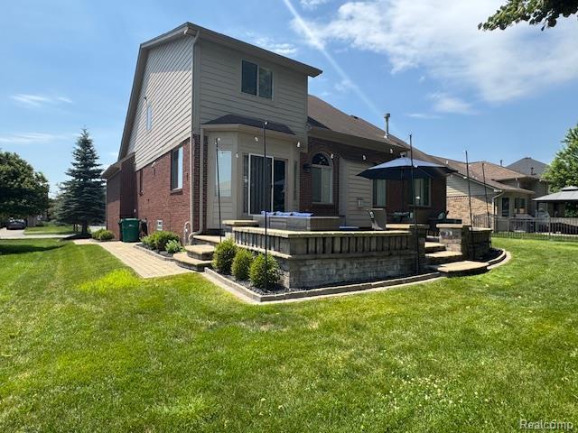 8535 Lillian Dr, Washington, MI 48094 - back of property featuring brick siding and a lawn