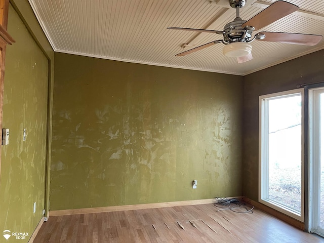 unfurnished room featuring ornamental molding, a ceiling fan, a wealth of natural light, and wood finished floors